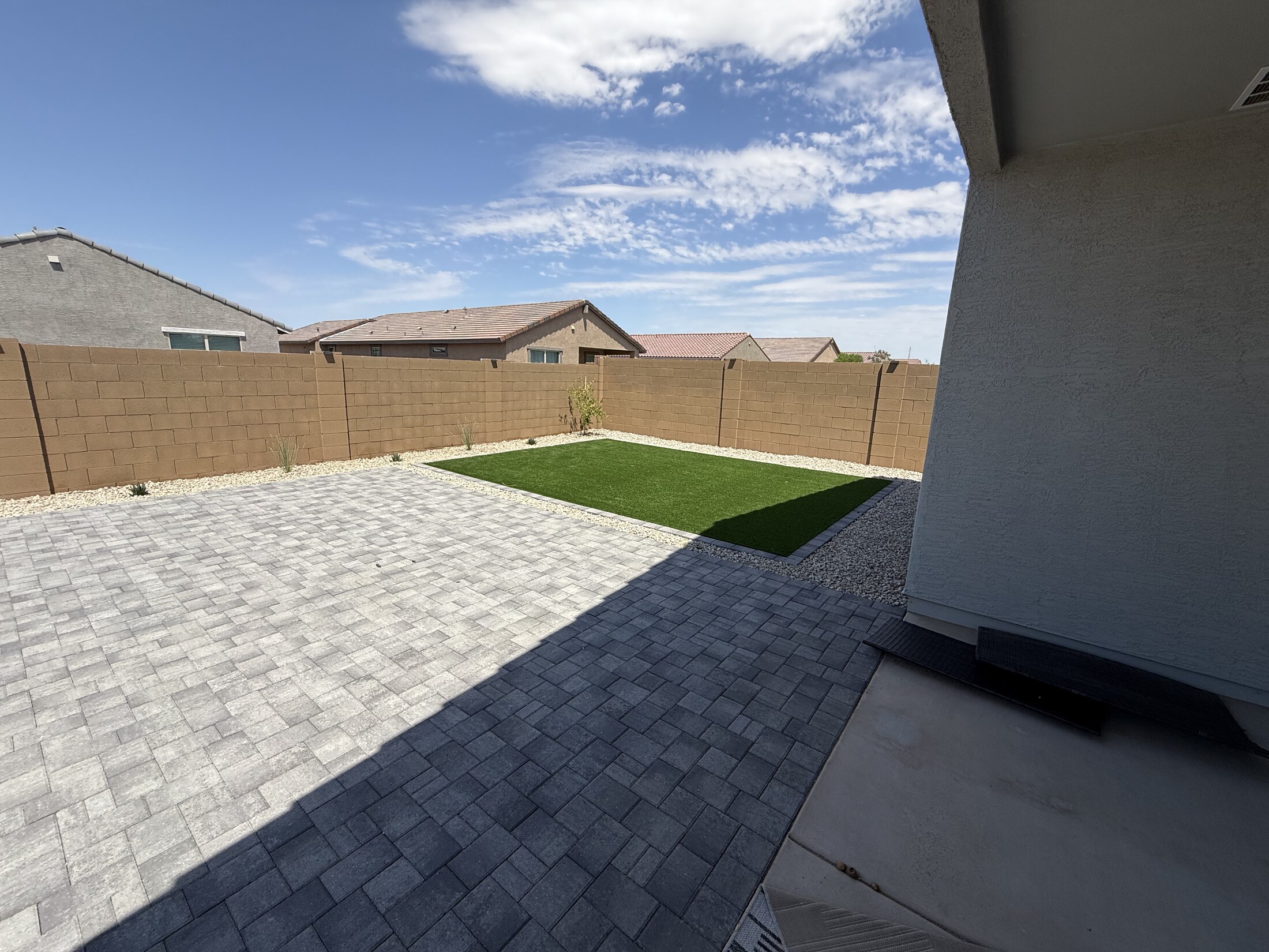 Paver patio next to gravel yard viewed from the home