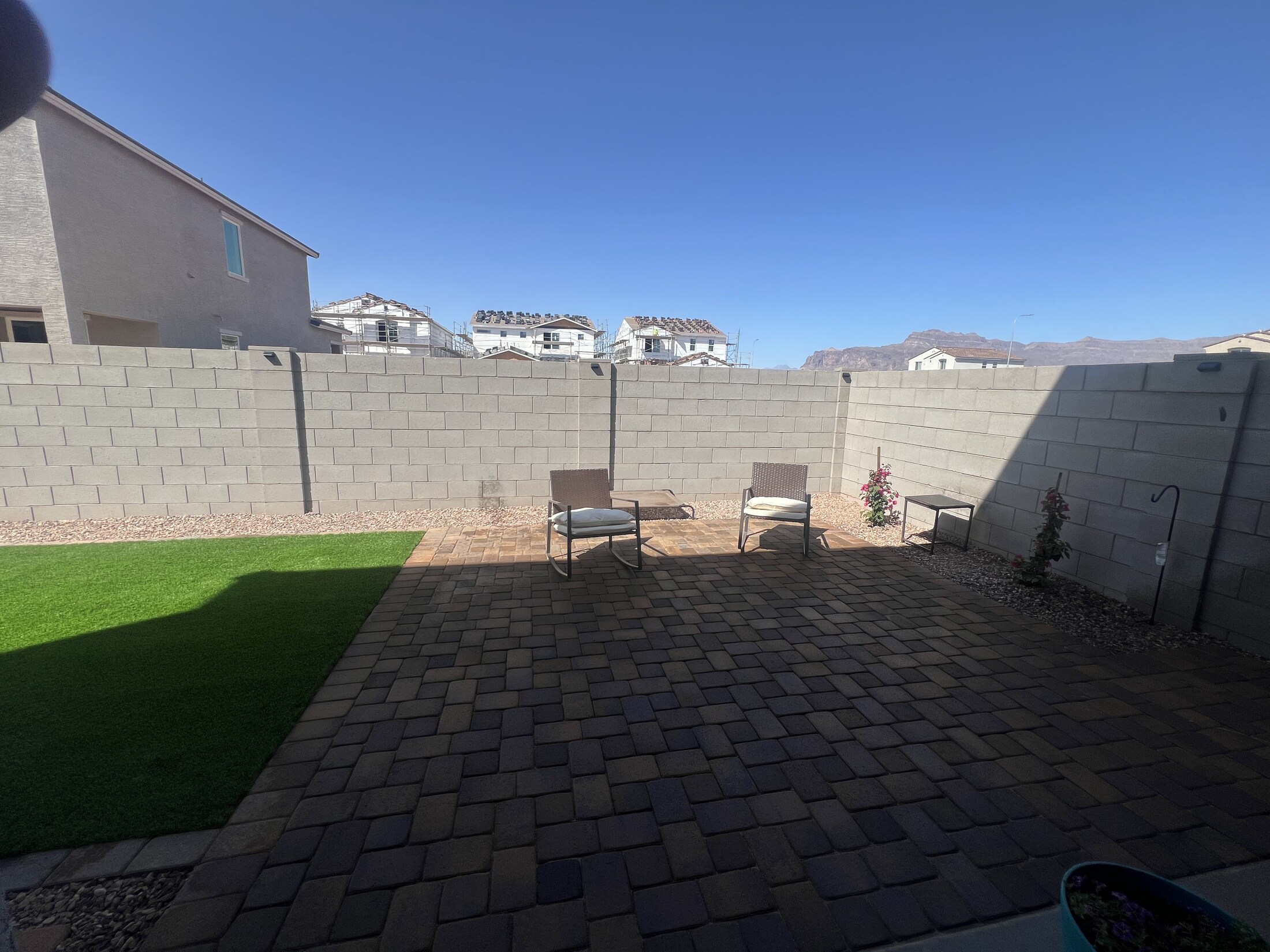Paver walkway framed by gravel and turf in a backyard