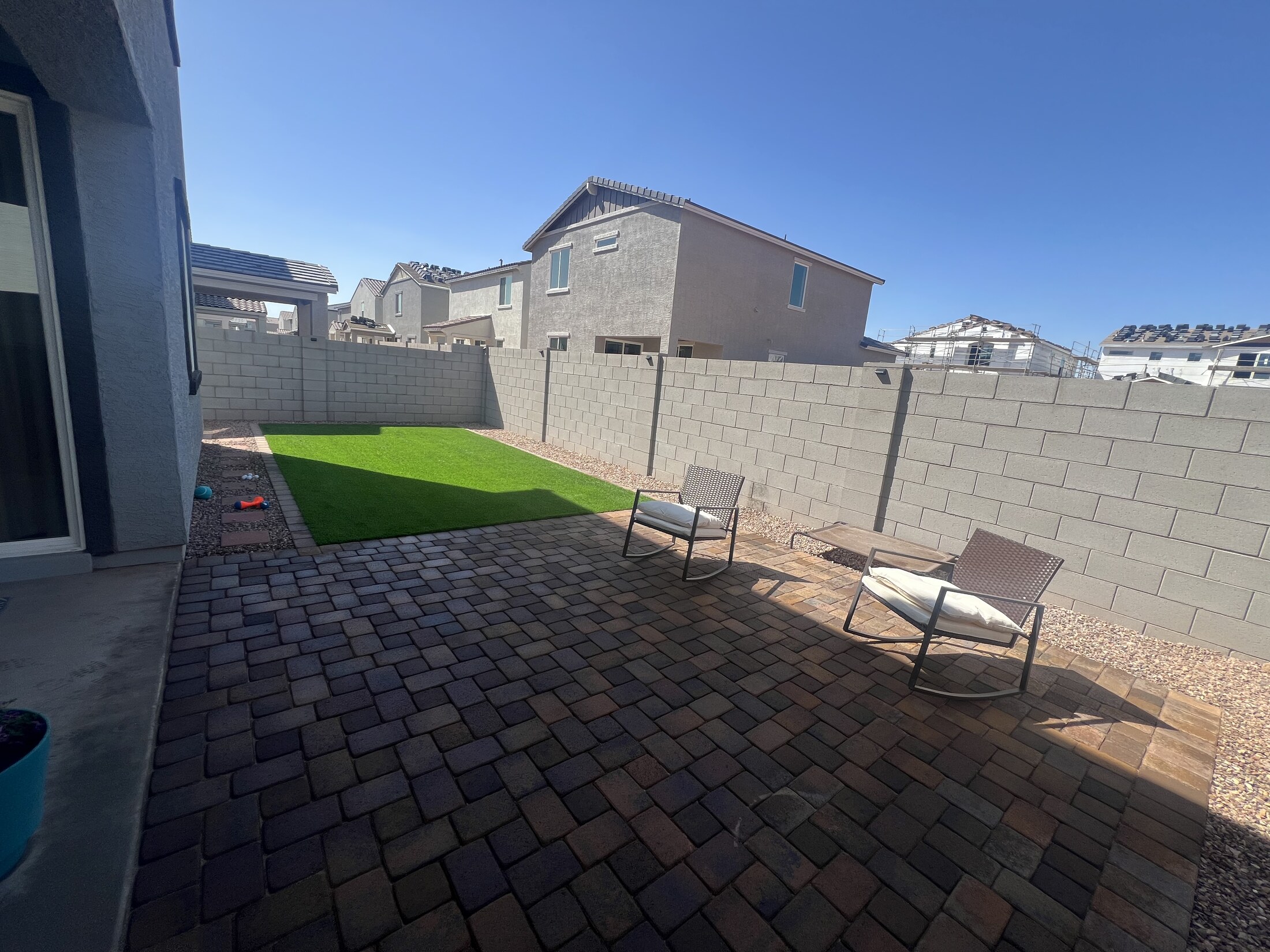 Covered patio overlooking a mixed paver, gravel, and turf backyard