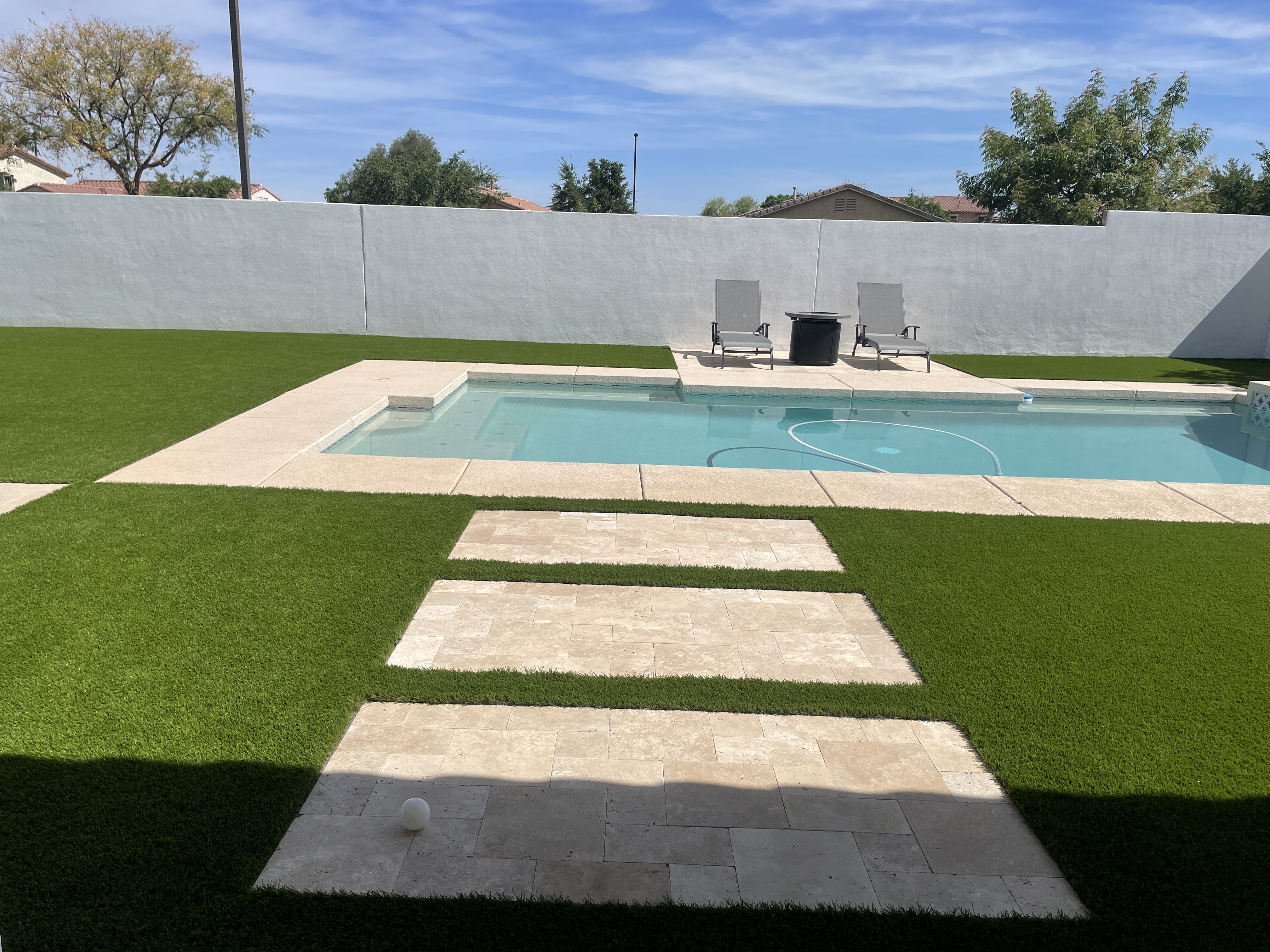 Paver stepping path leading to a backyard pool